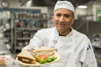 Chef passing over a sandwich