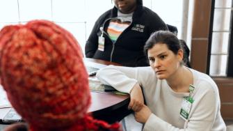 Two health care providers and a patient seated around a table